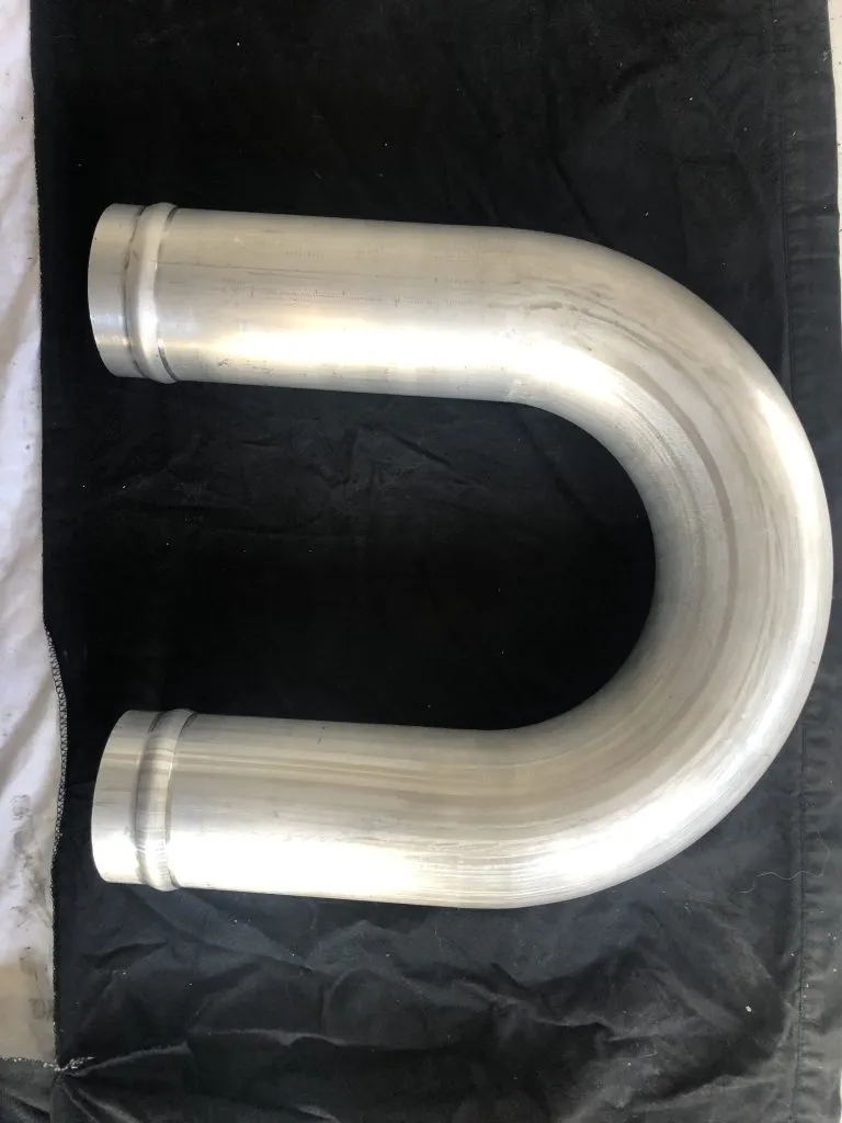 Generated placeholder image. A finished 180-degree aluminium handrail return with a straight tail, even wall through the bend.